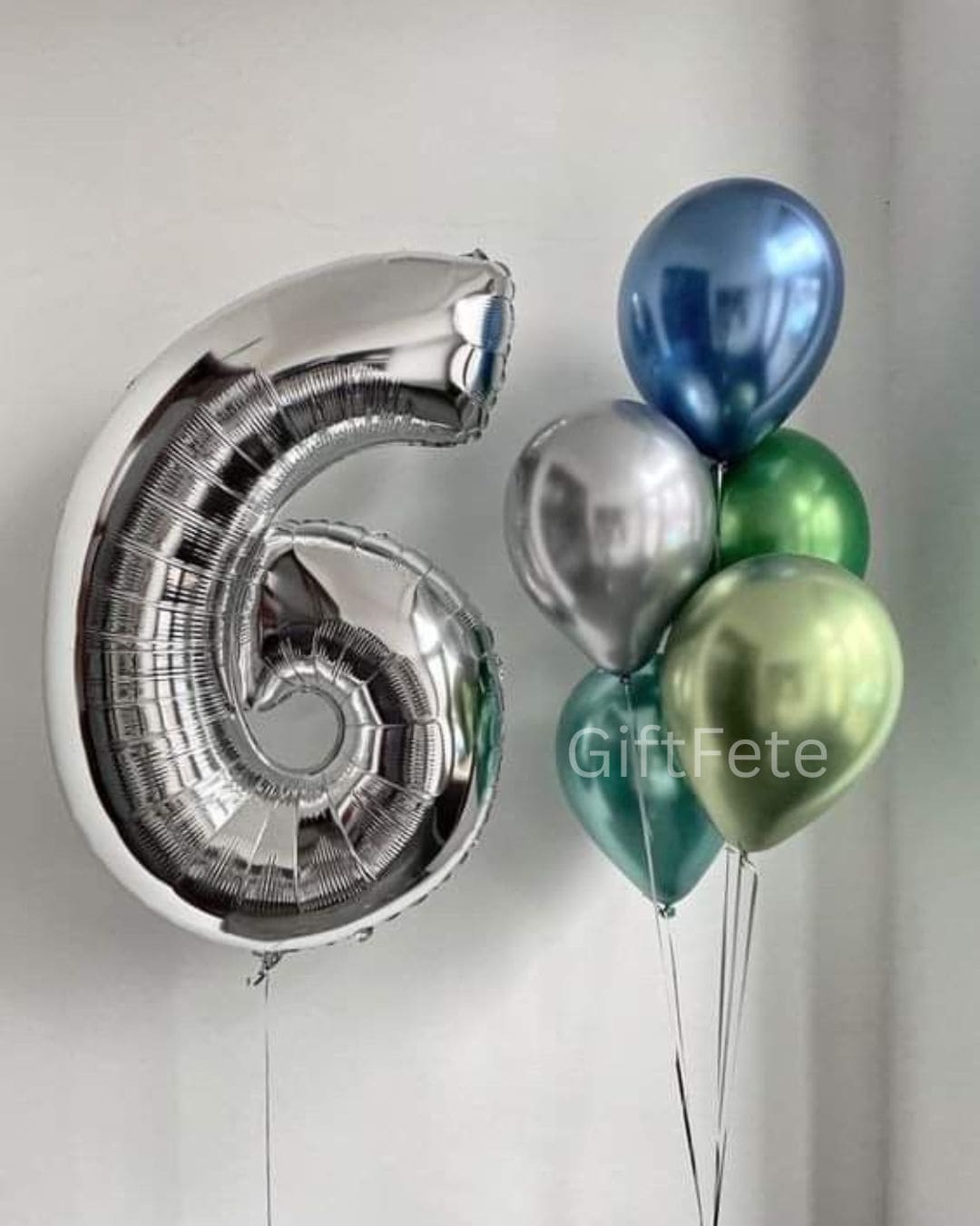 Silver number 6 balloon and cluster of green, blue, and silver balloons on a white background.