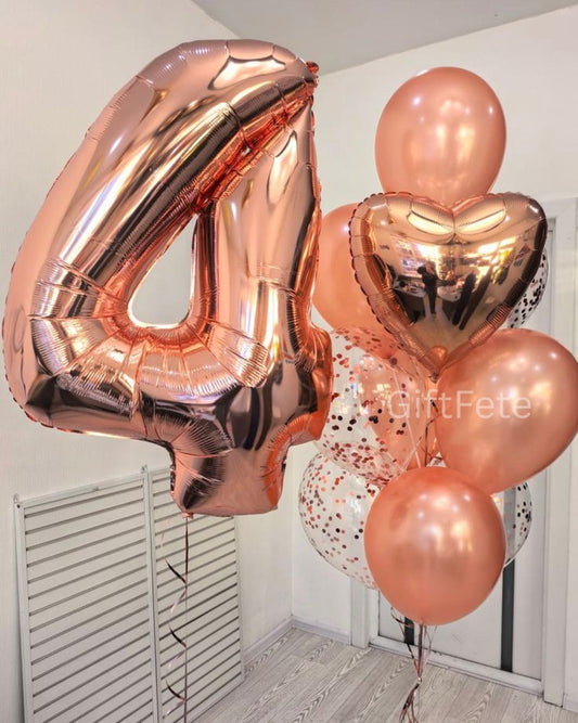 Rose gold balloons including a number 4 and heart shapes on a plain background.