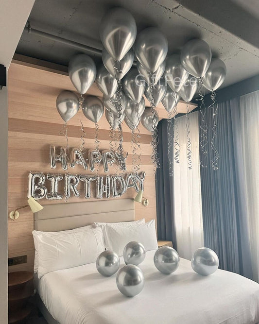 Silver balloons and 'Happy Birthday' banner in a bedroom setting