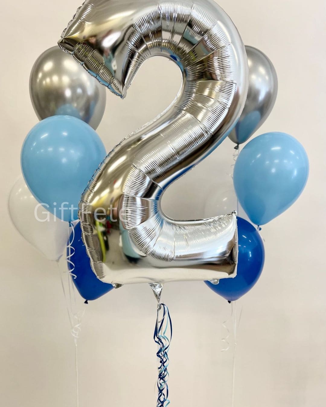 Silver number 2 balloon with blue and silver balloons on a white background